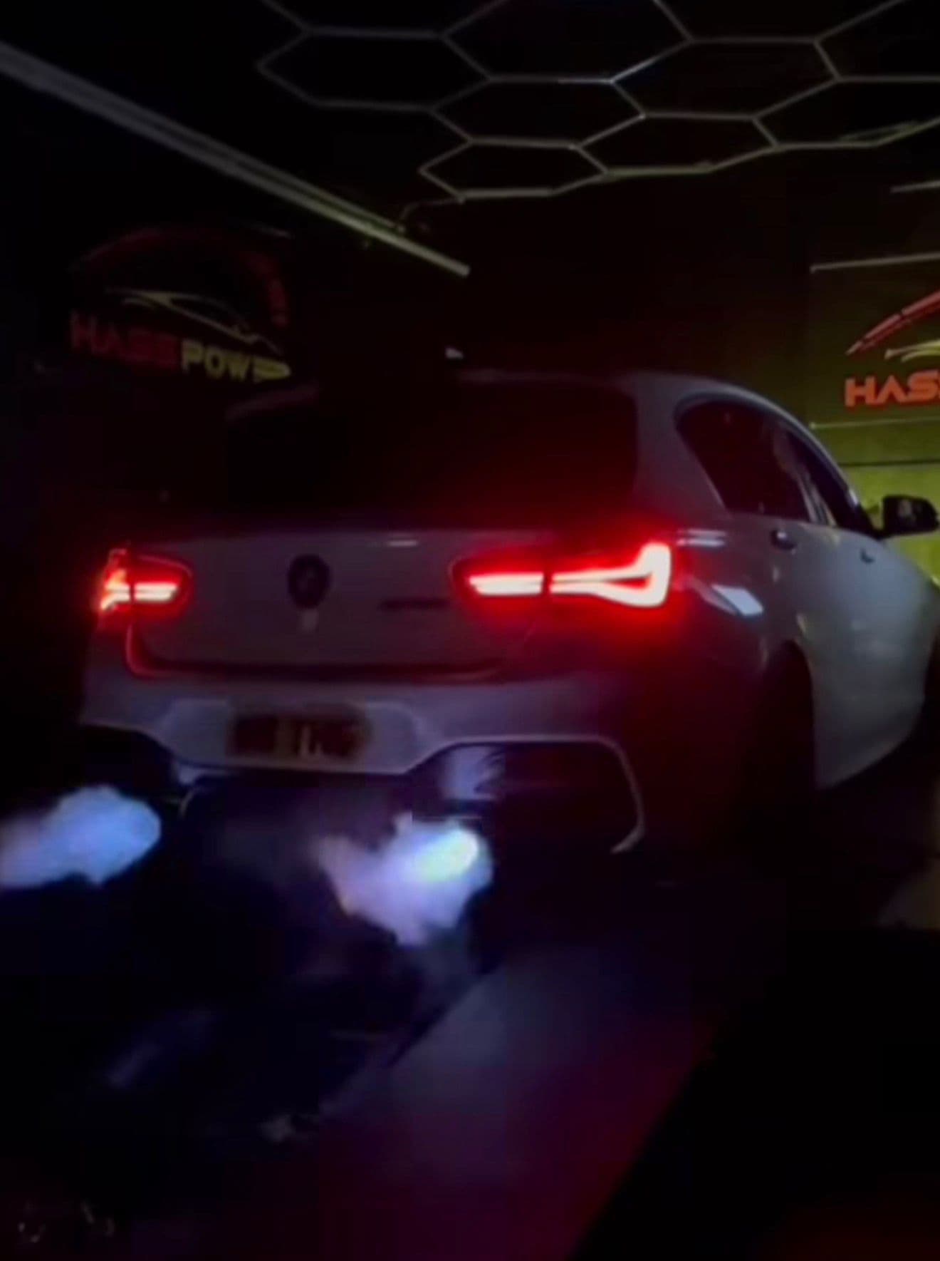 White BMW M140i on a dyno cell at Haas Power Scotland, cracking blue flames during a pull